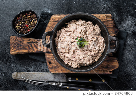 Duck pate Rillettes de Canard in a pan with greens. Black background. Top View Duck pate Rillettes de Canard in a pan with greens. Black background. Top View 84764903