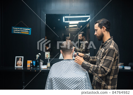 Master in barbershop makes men's haircutting with hair clipper Master in barbershop makes men's haircutting with hair clipper 84764982