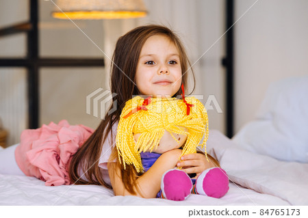 little girl with a toy on the bed little girl with a toy on the bed 84765173
