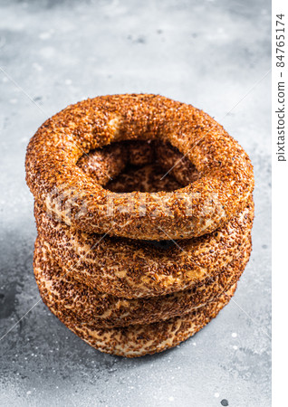 Turkish Bagel Simit with sesame traditional pastry. Gray background. Top view Turkish Bagel Simit with sesame traditional pastry. Gray background. Top view 84765174