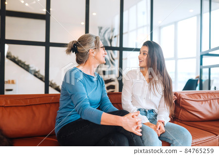 Young woman visiting grandmother at home, women talk 84765259