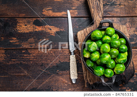 Boiled Brussels green sprouts cabbage in a pan. Dark wooden background. Top view. Copy space Boiled Brussels green sprouts cabbage in a pan. Dark wooden background. Top view. Copy space 84765331