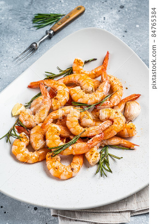 Fried Prawns Shrimps in a plate with herb and garlic. Gray background. Top view 84765384
