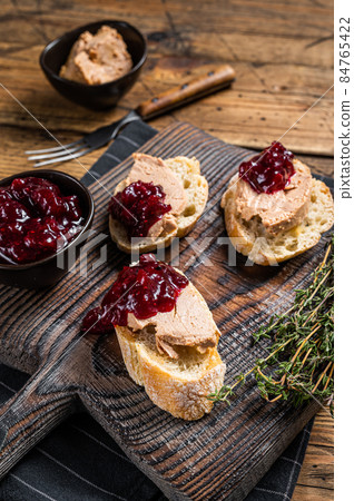 French cuisine Foie gras toasts, goose liver pate and lingonberry marmalade. wooden background. Top view 84765422