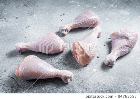 Raw uncooked chicken legs, drumsticks on stone table. Gray background. Top view Raw uncooked chicken legs, drumsticks on stone table. Gray background. Top view 84765553