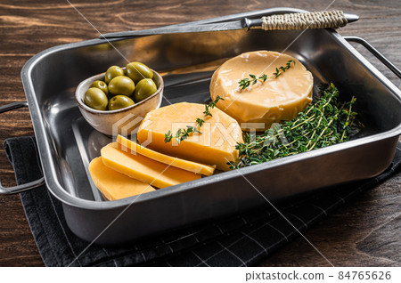 Fresh Halloumi sliced cheese in kitchen tray with thyme. Wooden background. Top view 84765626