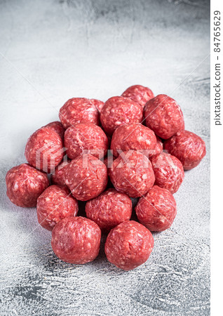 Uncooked Raw beef and pork meatballs with spices on kitchen table. White background. Top view 84765629