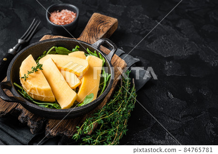 Halloumi cheese in pan ready for grilling. Black background. Top view. Copy space 84765781