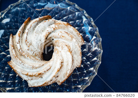 top view. homemade round cake with powdered sugar on a glass tray. top view. homemade round cake with powdered sugar on a glass tray. 84766020