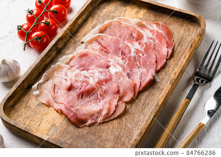 Italian prosciutto crudo or jamon, on white stone table background 84766286