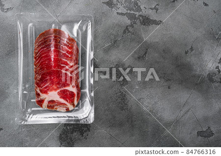 Cured meat coppa pack, on gray stone table background, top view flat lay, with copy space for text 84766316