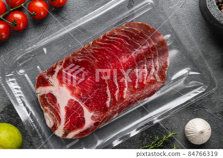 Italian meat cold cuts pack, on gray stone table background, top view flat lay Italian meat cold cuts pack, on gray stone table background, top view flat lay 84766319