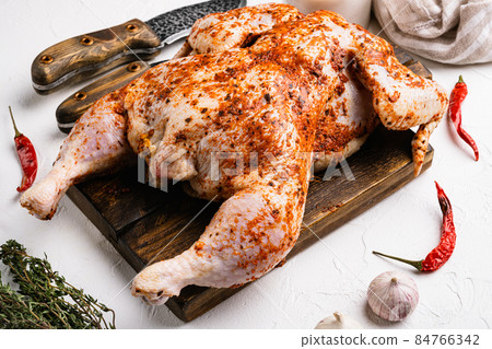 Marinated whole raw chicken tabaka, on white stone table background 84766342
