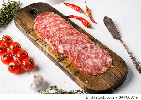 Thinly Sliced Milano salami, on white stone table background Thinly Sliced Milano salami, on white stone table background 84766379