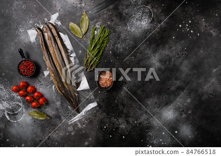 Fried river lamprey vacuum pack, on black dark stone table background, top view flat lay, with copy space for text Fried river lamprey vacuum pack, on black dark stone table background, top view flat lay, with copy space for text 84766518