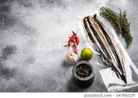 Fried river lamprey vacuum pack, on gray stone table background, with copy space for text Fried river lamprey vacuum pack, on gray stone table background, with copy space for text 84766529