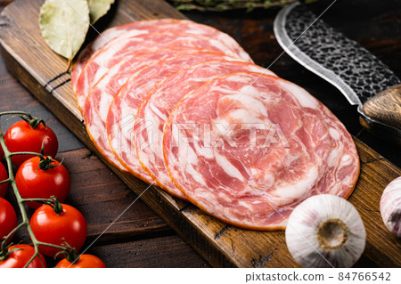 Sliced smoked sausage, on old dark wooden table background 84766542