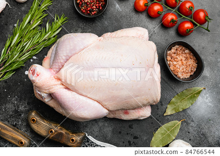 Organic raw whole chicken, on black dark stone table background, top view flat lay Organic raw whole chicken, on black dark stone table background, top view flat lay 84766544