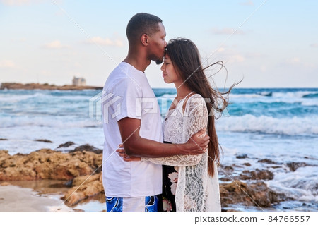 Kiss of a loving young couple, sea sky background. Kiss of a loving young couple, sea sky background. 84766557