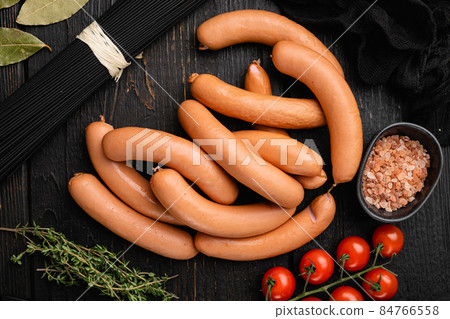 Raw roll sausages, on black wooden table background, top view flat lay Raw roll sausages, on black wooden table background, top view flat lay 84766558
