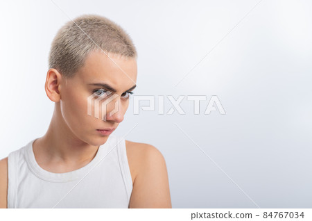Displeased young caucasian woman with short haircut on white background. 84767034