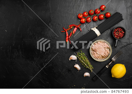 Pasta with tuna raw ingredients, on black dark stone table background, top view flat lay, with copy space for text 84767493