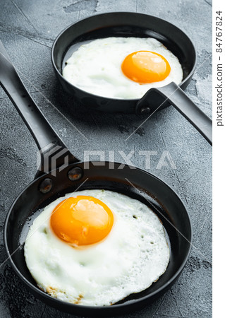 Fried Egg with ingredients in cast iron frying pan, on gray background Fried Egg with ingredients in cast iron frying pan, on gray background 84767824