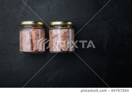Tuna fillet canned, on black background, top view with copy space for text Tuna fillet canned, on black background, top view with copy space for text 84767884