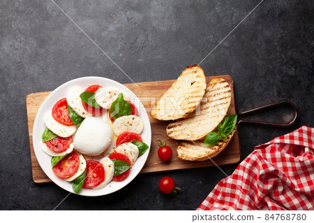 Caprese salad with mozzarella, basil and garden tomatoes 84768780