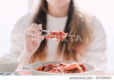 拿著韓國菜用筷子蒸排骨的女人 84769004