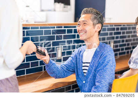 A man making an e-commerce payment at a restaurant 84769205