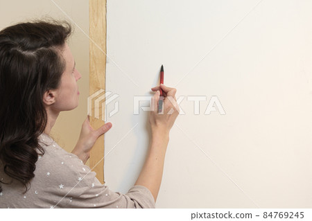 The artist draws with pencil on a white canvas. View from behind the shoulder. Drawing with watercolors in a home art studio. The artist draws with pencil on a white canvas. View from behind the shoulder. Drawing with watercolors in a home art studio. 84769245