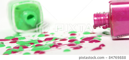 Pink and Green Spilled Nail Polish on White Background 84769888