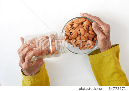 close up senior women hand holding a bowl on almond close up senior women hand holding a bowl on almond 84772271