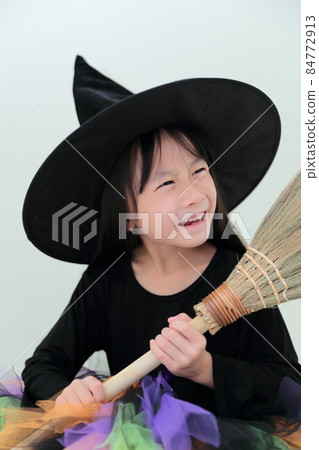 Toddler girl dressed as a witch on Halloween 84772913