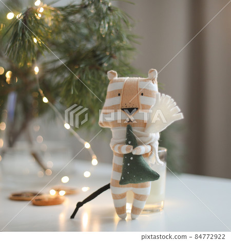 cute soft toy tiger with decorations on a cozy Christmas or New Year background. symbol of 2022, oriental calendar concept cute soft toy tiger with decorations on a cozy Christmas or New Year background. symbol of 2022, oriental calendar concept 84772922