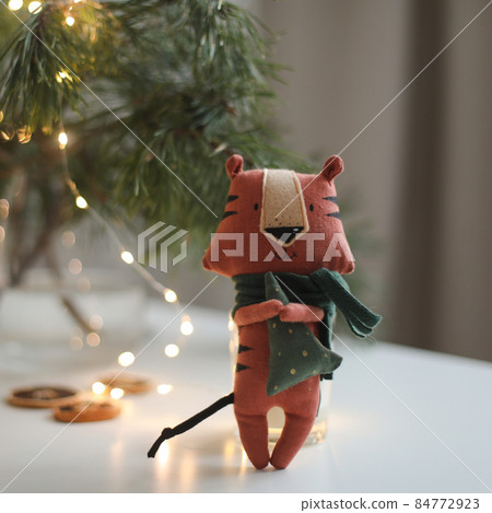 cute soft toy tiger with decorations on a cozy Christmas or New Year background. symbol of 2022, oriental calendar concept cute soft toy tiger with decorations on a cozy Christmas or New Year background. symbol of 2022, oriental calendar concept 84772923