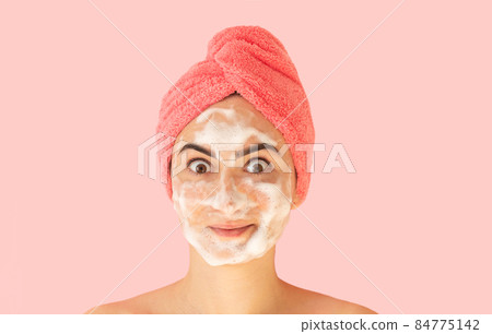Happy woman with soap sud foam for wash face 84775142