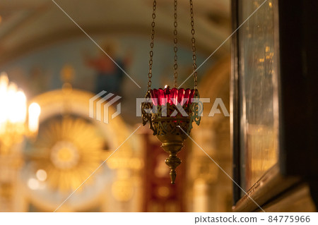 Orthodox Church. Christianity. Festive interior decoration with burning candles and icon in traditional Orthodox Church on Easter Eve or Christmas. Religion faith pray symbol 84775966
