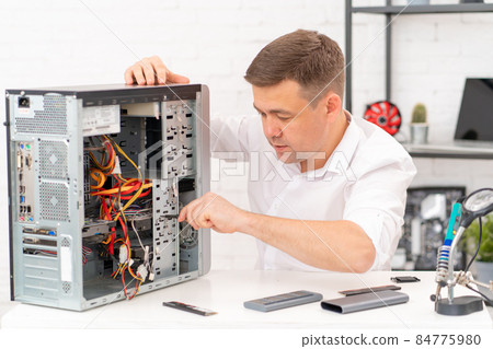 a man installs hard disk . computer repair shop. professional services. a man installs hard disk . computer repair shop. professional services. 84775980