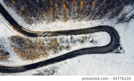 Aerial high angle view of narrow curvy road. 84776226