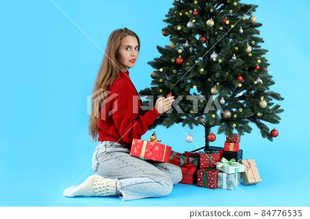 Attractive woman, Christmas tree and gift boxes on blue background 84776535