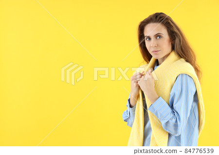 Attractive woman in shirt with sweater on yellow background 84776539