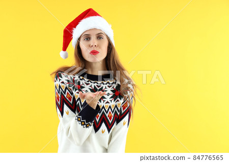 Attractive woman in Santa hat on yellow background 84776565