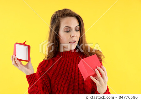 Attractive woman with gift box on yellow background 84776580