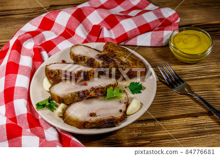 Baked pork belly in a plate on wooden table Baked pork belly in a plate on wooden table 84776681