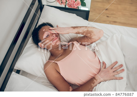 A young dark-skinned woman lying in bed A young dark-skinned woman lying in bed 84776887