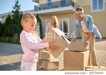 Cute family unpacking cardboard boxes while moving to a new house Cute family unpacking cardboard boxes while moving to a new house 84776945
