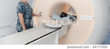 Doctor or nurse and patient with tomography CT or MRI Scan in hospital. Interior of radiography department. Technologically advanced equipment in white room. Magnetic resonance diagnostics machine. Doctor or nurse and patient with tomography CT or MRI Scan in hospital. Interior of radiography department. Technologically advanced equipment in white room. Magnetic resonance diagnostics machine. 84777009