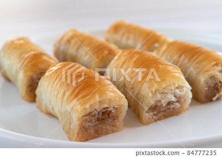 Turkish sweetness - baklava on a white plate close-up. Turkish sweetness - baklava on a white plate close-up. 84777235